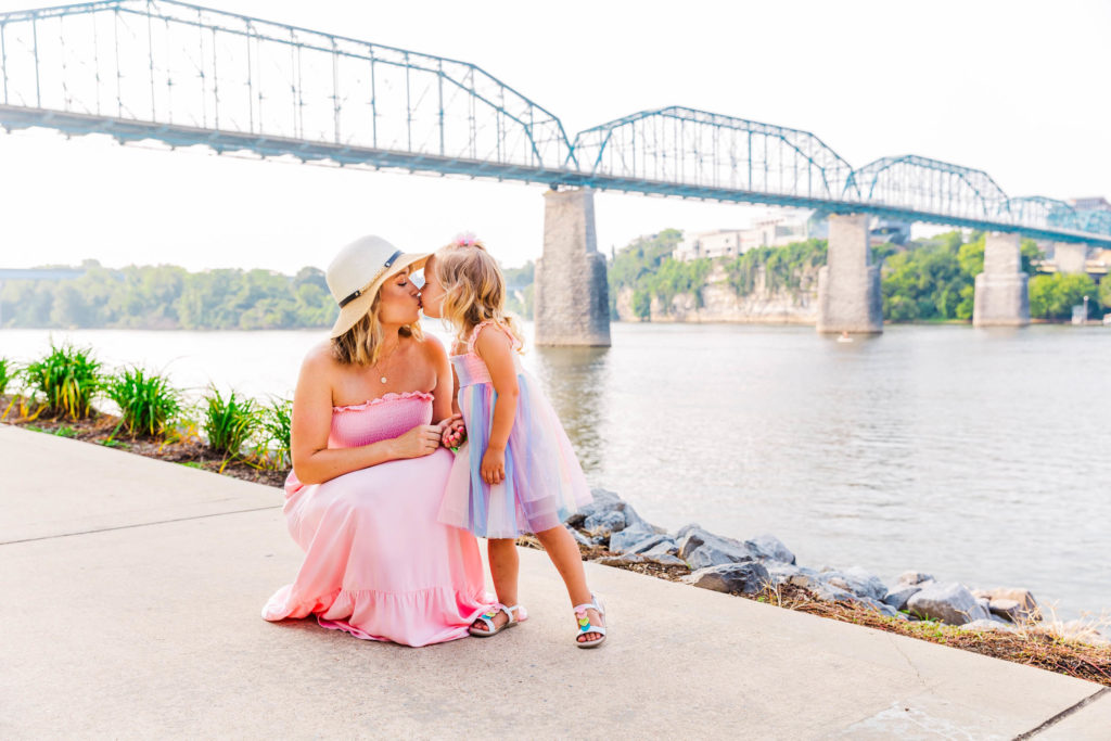 Chattanooga Family Photos at Coolidge Park, mother and daughter sweet kiss in front of Walnut Street Bridge - location in downtown Chattanooga