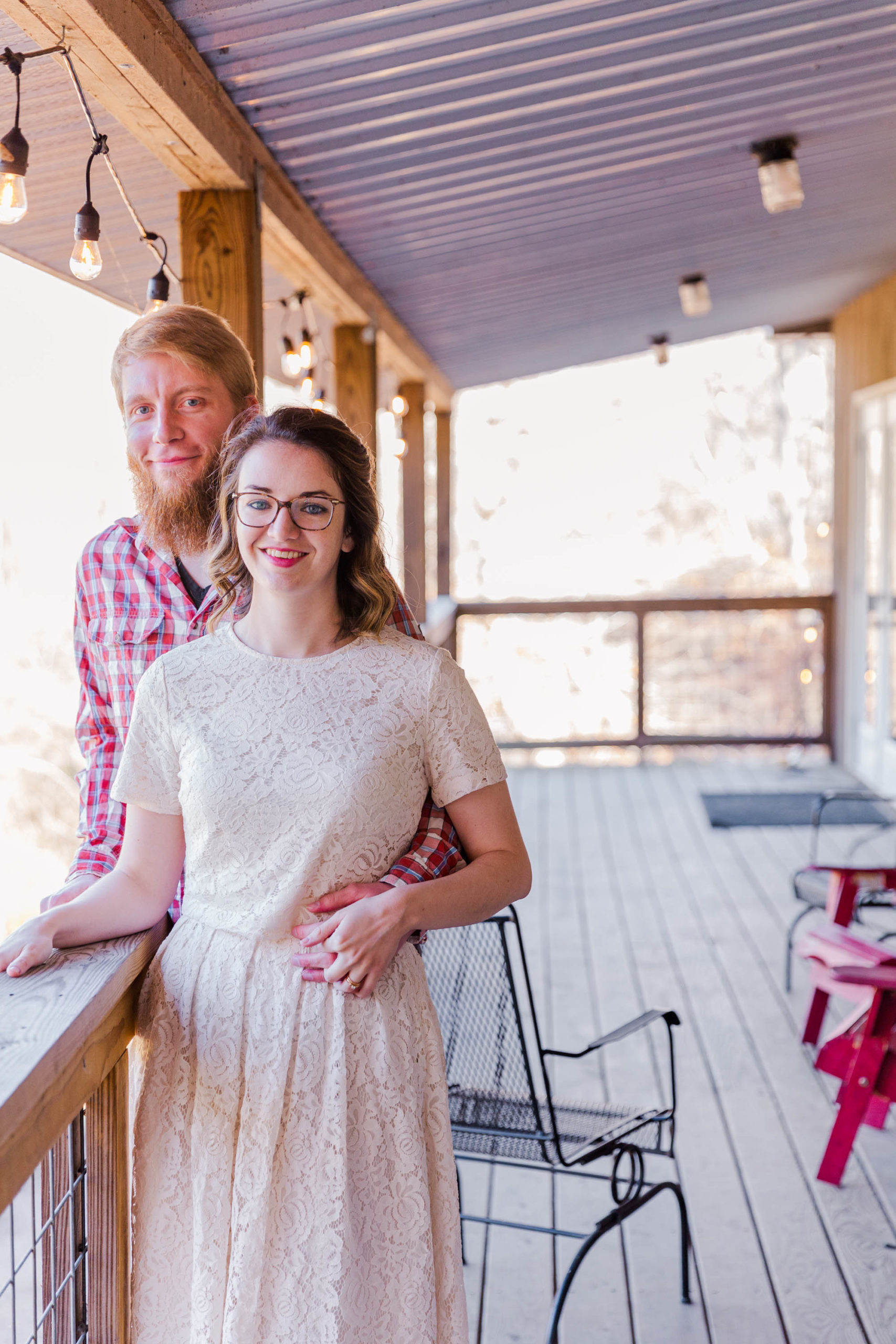 Couple poses on upstairs porch at Pigeon Mountain Crossing in LaFayette, Georgia