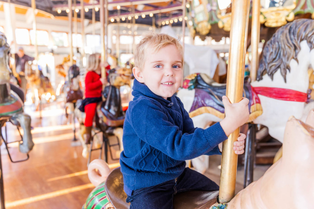 Chattanooga Family Photos at the Coolidge Park carousel, brother and sister share a ride on the carousel in downtown Chattanooga