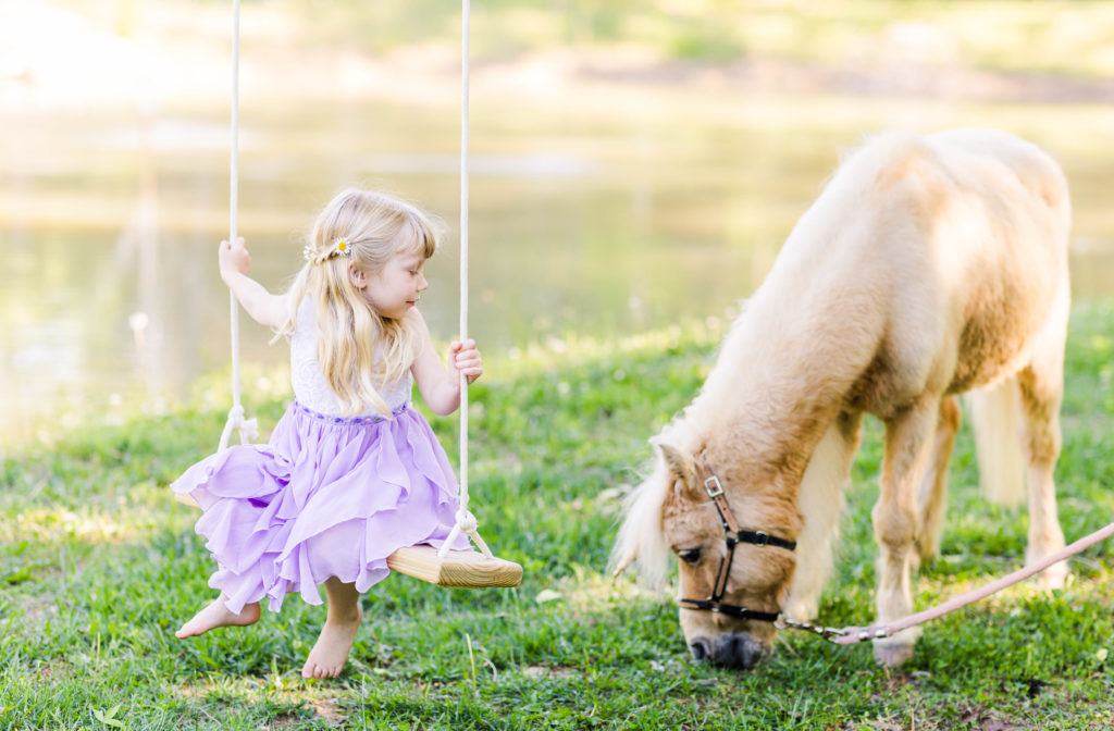 Little girl swings near Wesley the unicorn in a photo by Elle Bea Photography in Chickamauga, Georgia near Chattanooga, Tennessee