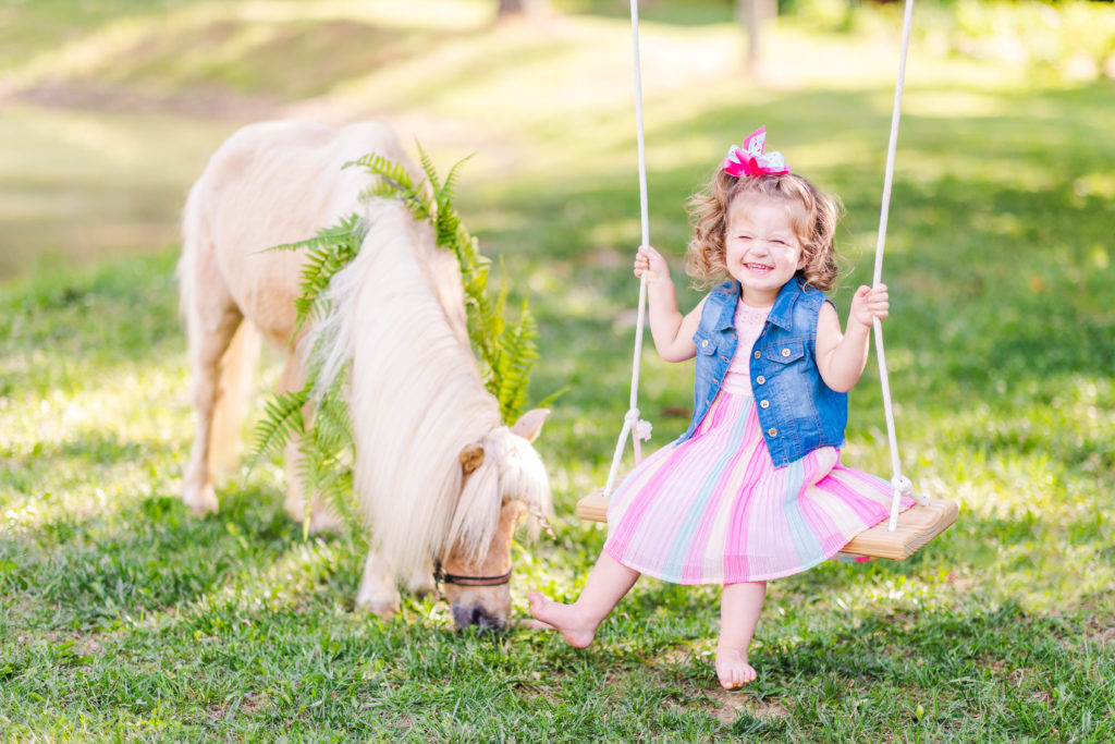 Little girl smiles with Wesley the unicorn in a photo by Elle Bea Photography in Chickamauga, Georgia near Chattanooga, Tennessee