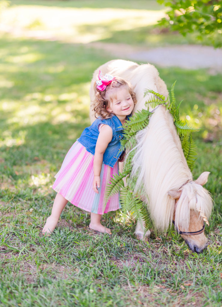 Little girl hugs Wesley the unicorn in a photo by Elle Bea Photography in Chickamauga, Georgia near Chattanooga, Tennessee