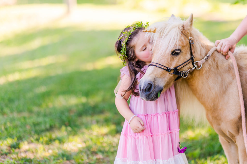 Little girl kisses Wesley the unicorn in a photo by Elle Bea Photography in Chickamauga, Georgia near Chattanooga, Tennessee