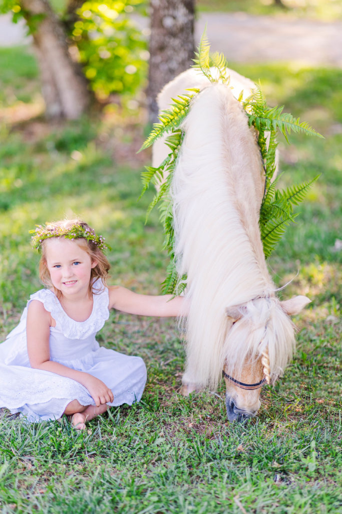 Little girl pets Wesley the unicorn in a photo by Elle Bea Photography in Chickamauga, Georgia near Chattanooga, Tennessee