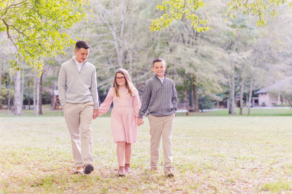 Brothers and sister walk and smile at Chattanooga Farm Mini Sessions in Hixson, Tennessee with Elle Bea Photography