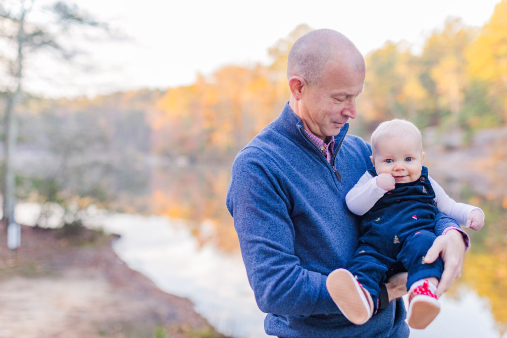 Dad and baby boy smile during 2022 family photography at Stone Mountain Park in Stone Mountain, Georgia