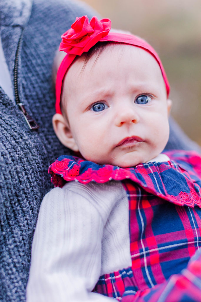 Baby girl with big blue eyes closeup during 2022 family photos