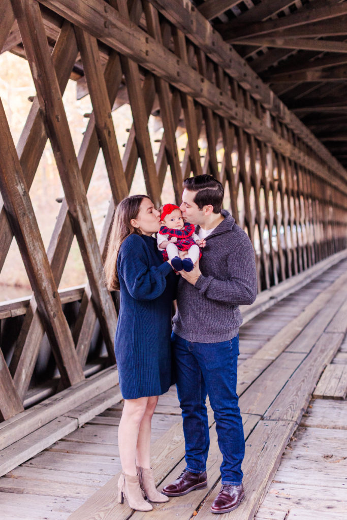 Mueller family baby girl kisses on the bridge at Stone Mountain Park in Stone Mountain, Georgia