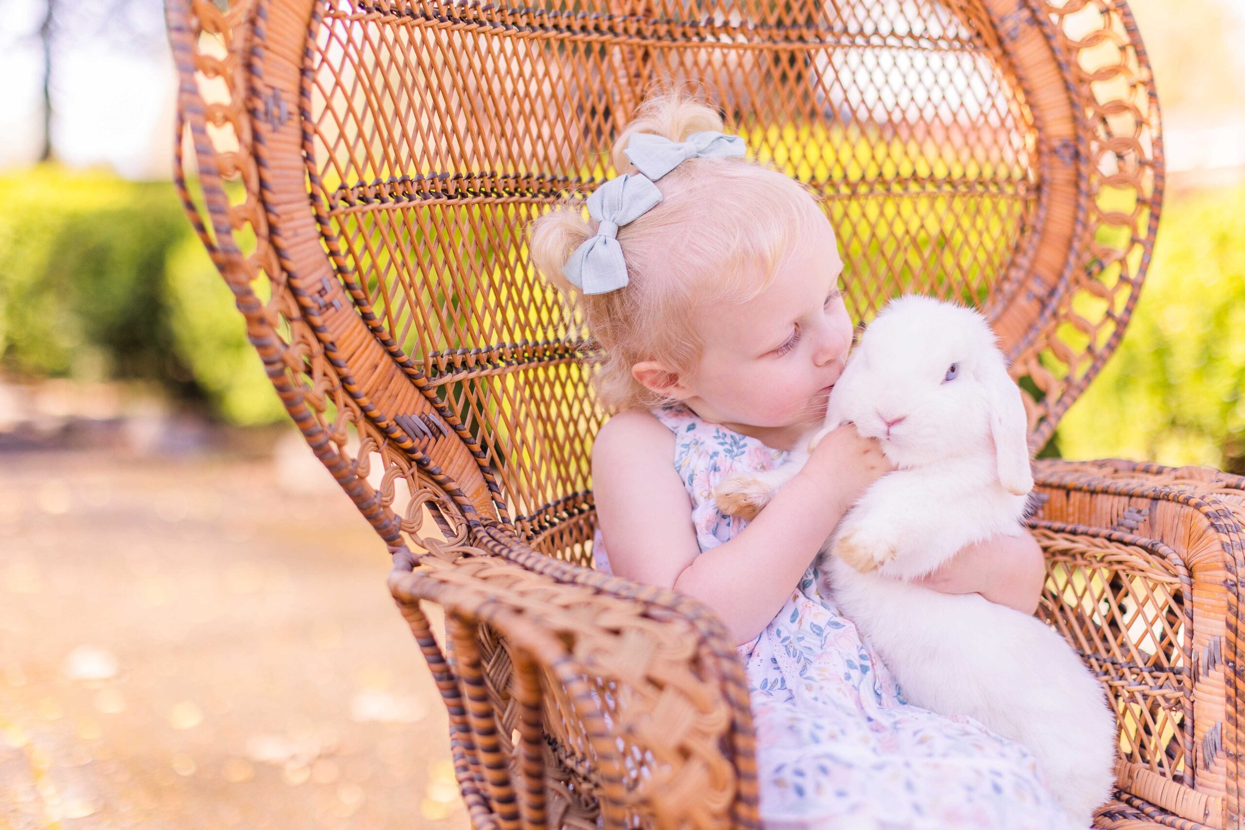 Toddler girl kisses white bunny at live bunny Easter mini sessions 2023 in Chickamauga, Georgia in Walker County