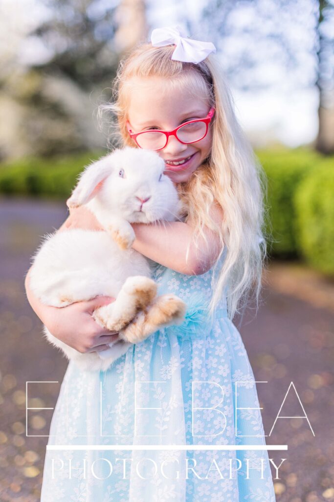 Girl cuddles white bunny at live bunny Easter mini sessions in Walker County, Georgia