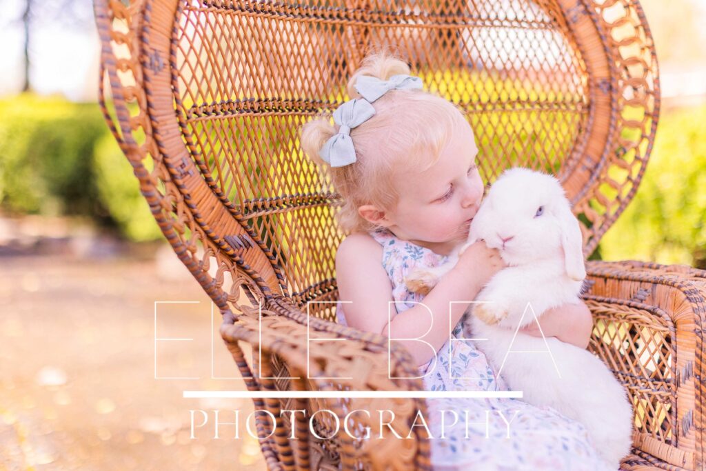 Toddler girl kisses white bunny at live bunny Easter mini sessions 2023 in Chickamauga, Georgia in Walker County