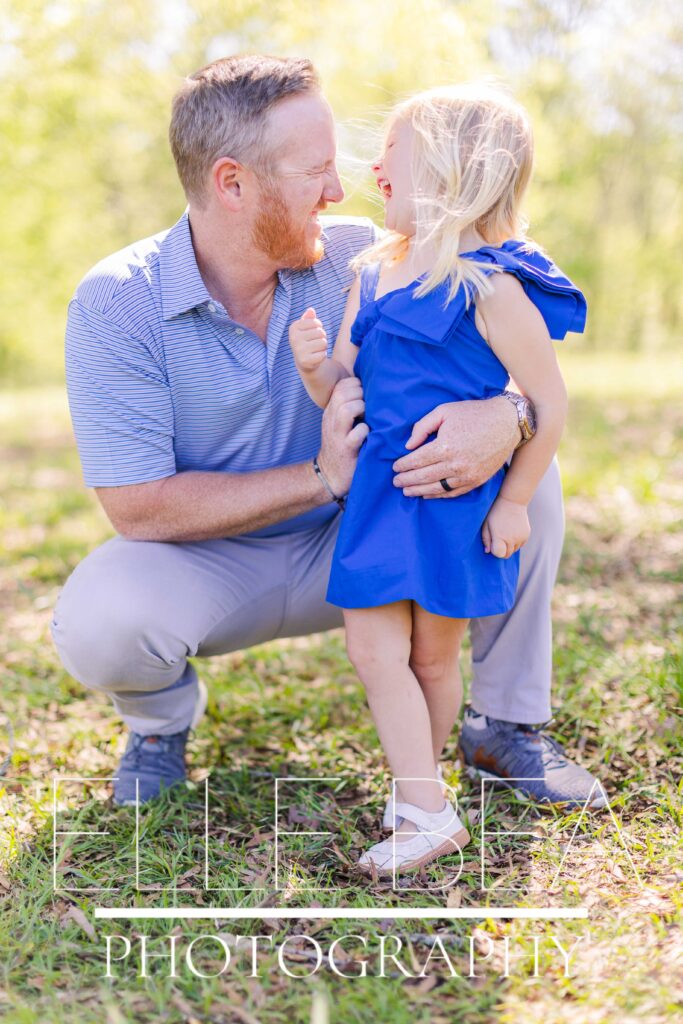 Dad and toddler daughter laugh together during family mini sessions at the battlefield in Chickamauga, Georgia