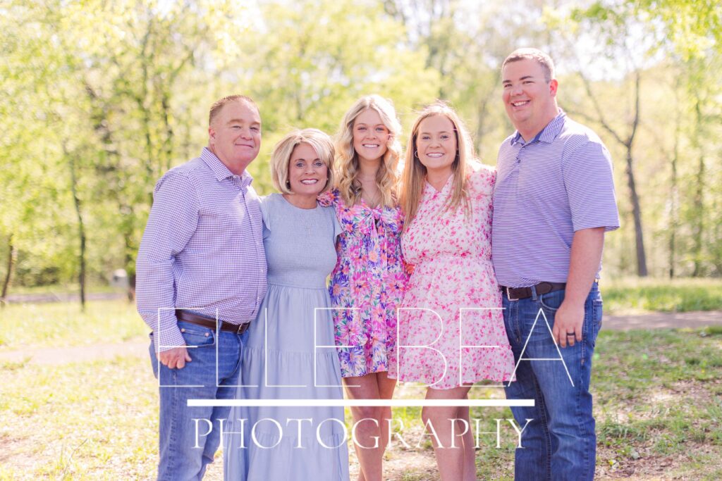 Parents and adult daughters + son in law smile and pose during spring mini sessions