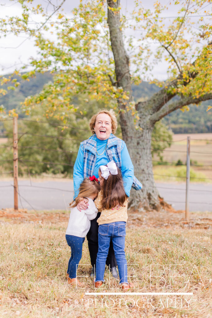 Grandmother laughs with granddaughters on a chilly day during a photoshoot at Mountain Cove Farms