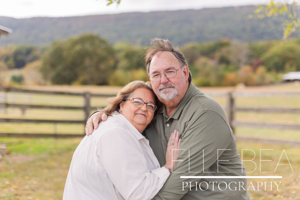 Couple poses for a photo during a cloudy photoshoot at Mountain Cove Farms
