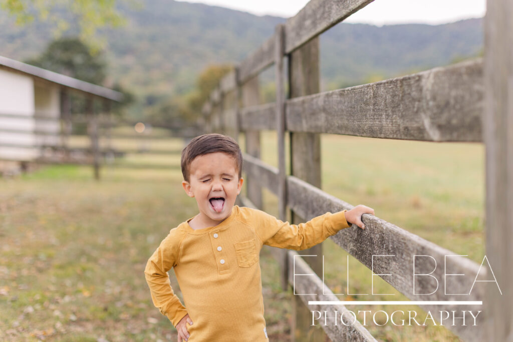 Little boy makes a silly face during a cloudy mini session photoshoot with Elle Bea Photography