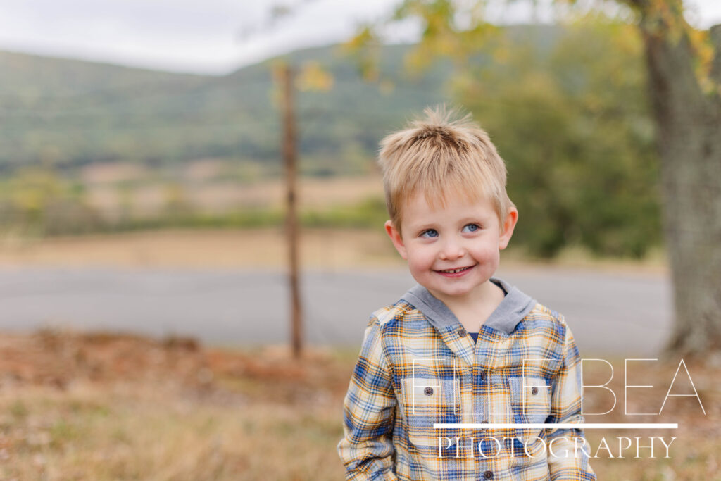 Little boy smiles on a cool cloudy day during mini sessions at Mountain Cove Farms