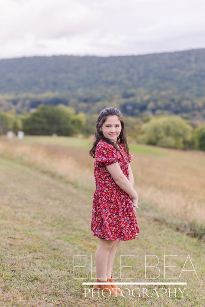 Girl poses in front of a beautiful valley at Mountain Cove Farms
