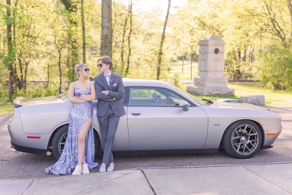 Prom couple poses in front of their prom car during a prom photo session at the Chickamauga Battlefield in Chickamauga, Georgia
